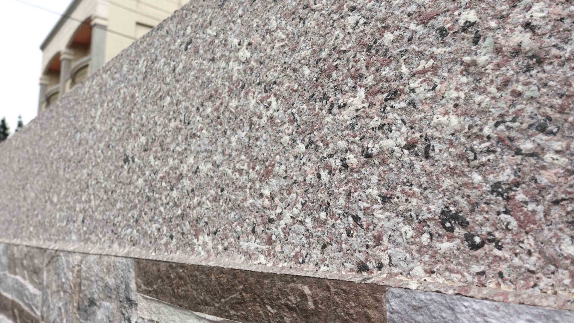 La cerca está recubierta con ADD STONE revestimiento con textura de granito, que encaja con la piedra real debajo.